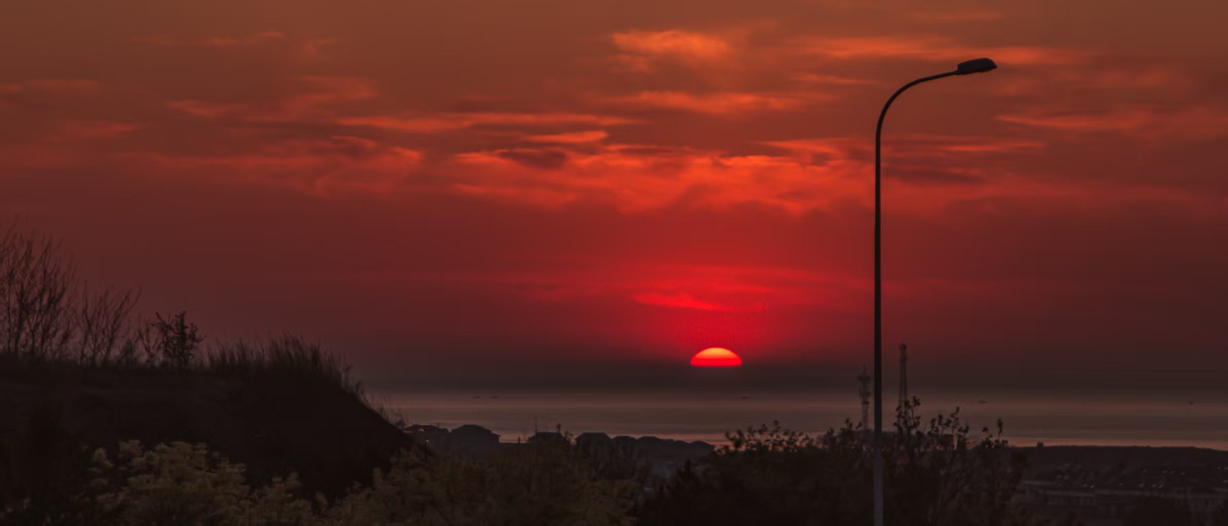 Red sunset over a coastal field